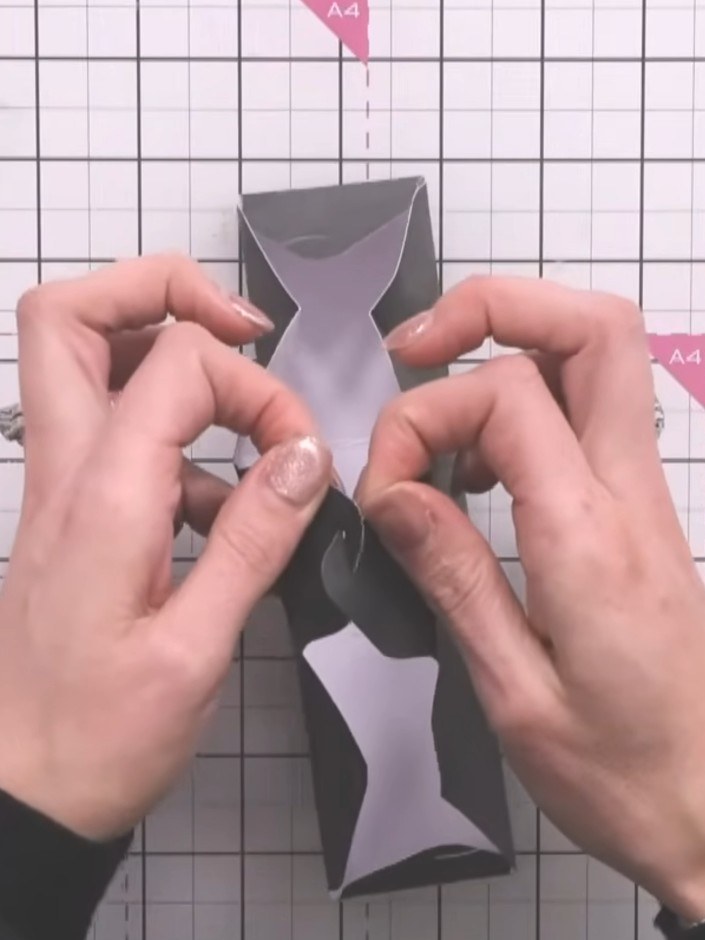 Step 8: Klapp die Seiten der Box hoch. Häng die Ösen an jeder Ecke ineinander, damit die Box ohne Kleber hält.
