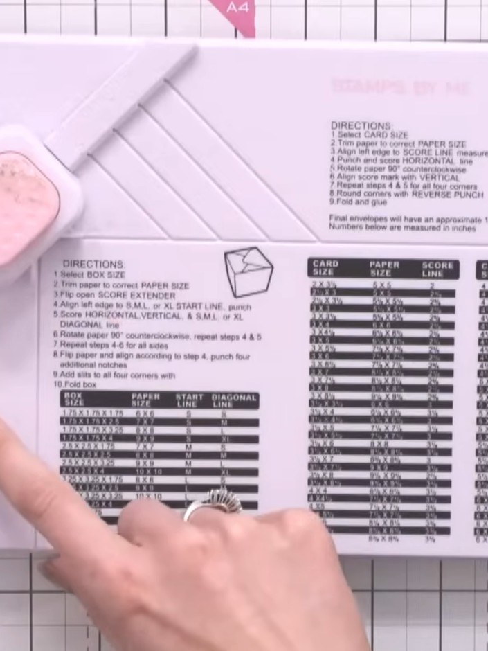 Step 2: Place your paper on the 'four' line of the envelope section on your box and envelope maker board. Score down t
