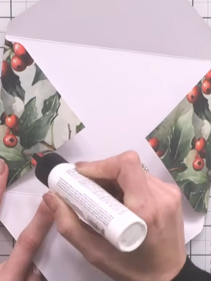 Step 8: Glue down the decorative paper flaps on the envelope. Tuck in any excess paper at the corners for a neat, prof