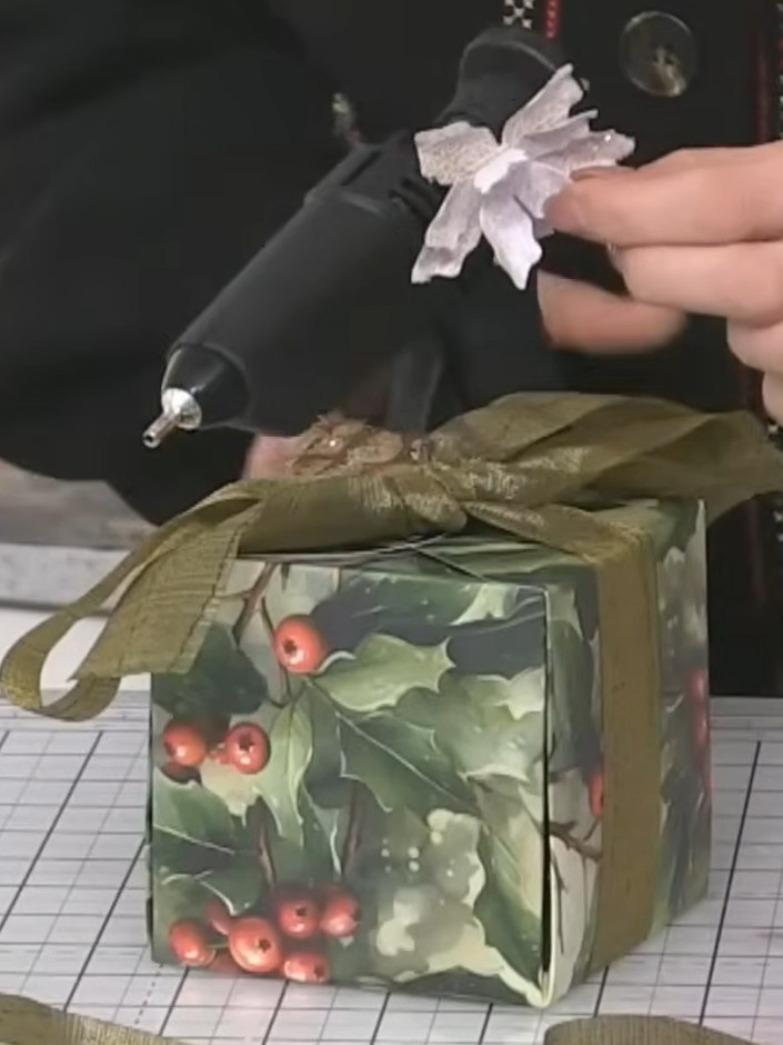 Step 5: Add die-cut holly and berry greenery around the flowers on the gift box. Distress the edges of the greenery wi