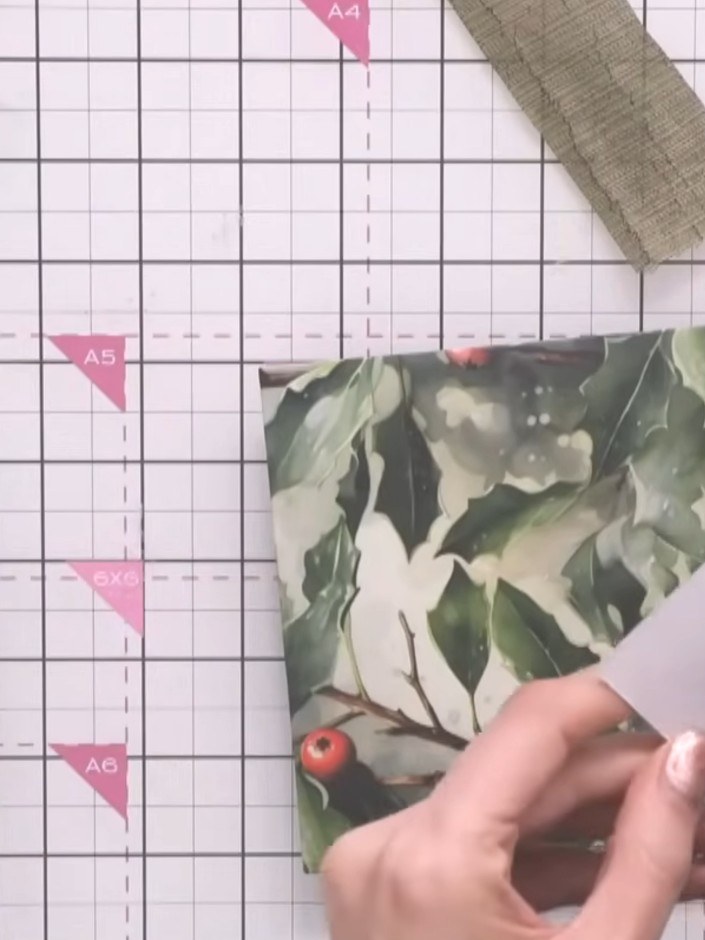 Step 3: Attach the die-cut poinsettia flowers to the top of the envelope panel using hot glue. Position the flowers wi
