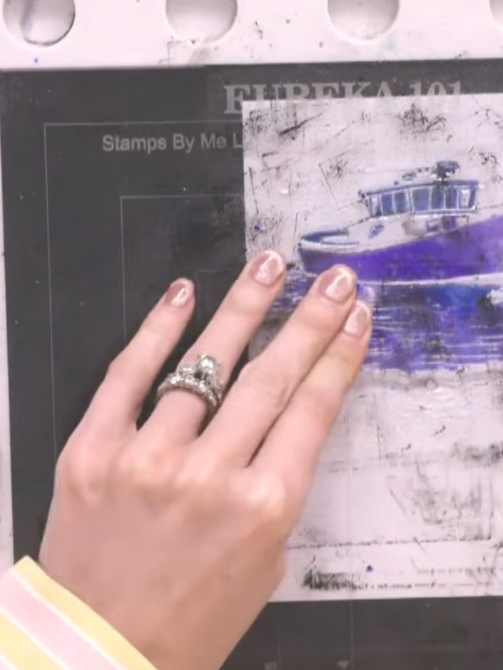 Step 4: Carefully lift the stamp away from the card to reveal the painted boat image. Allow the card to dry slightly, 
