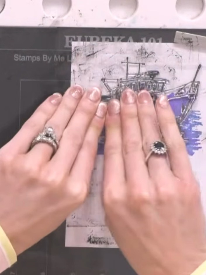 Step 7: Press down firmly on the lamination stamp with both hands and lift straight up to reveal the detailed fishing 