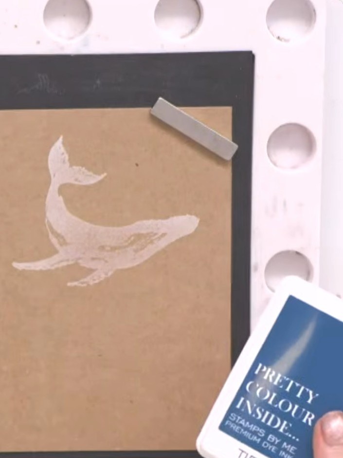 Step 4: Ink the same solid whale stamp with teal or blue ink. Lightly spray the inked stamp with water to blend the co