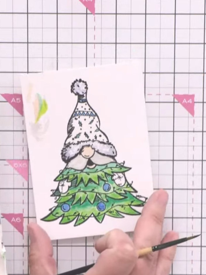 Step 2: Colour the Christmas tree with watercolours, using lighter green at the bottom and darker green at the top to 