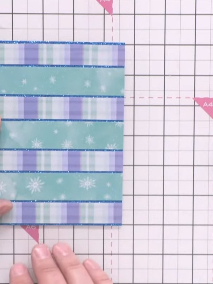 Step 9: Mount the striped background panel onto a craft card blank using adhesive. Ensure the panel is centred and adh