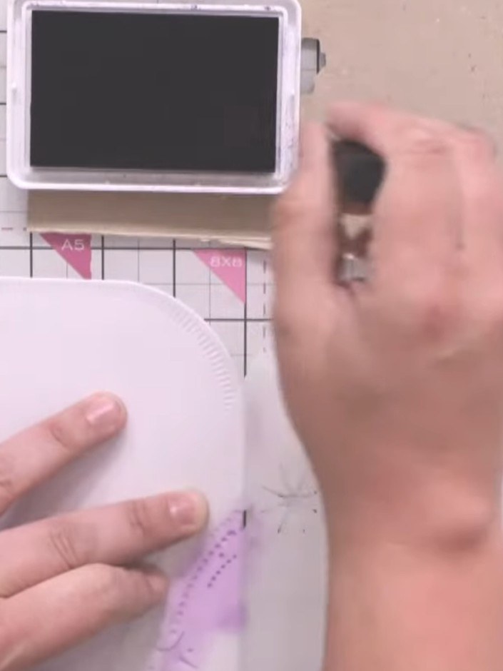 Step 3: Position the stencil on your card base and apply purple glitter paste through the stencil opening using a pale