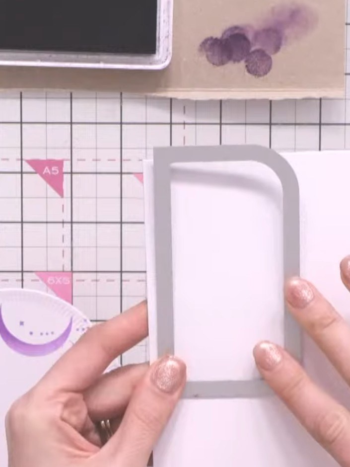 Step 7: Position the patterned paper panel with the purple celestial design so it hangs slightly over the top of the w