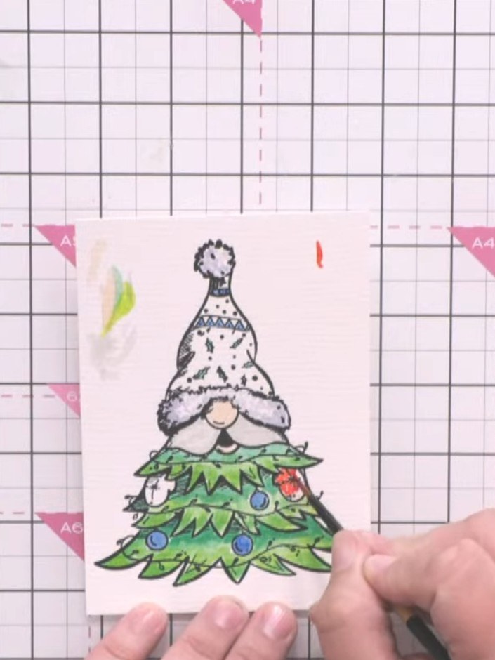 Step 4: Add colour to the Christmas tree ornaments using watercolour paints. Paint the baubles in red and blue, keepin