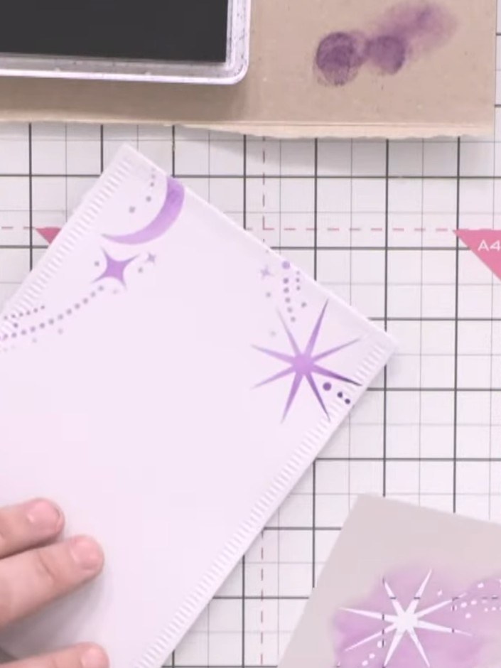 Step 4: Use a smaller nesting die to cut a shape from the purple patterned paper with stars and moons. This will creat