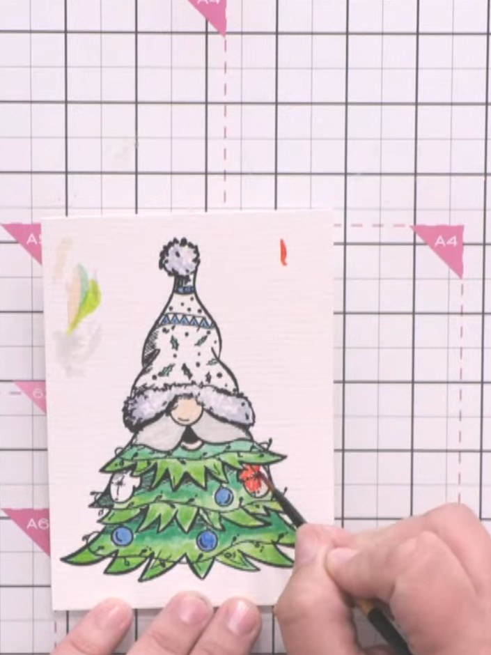 Step 2: Colour the Christmas tree with watercolours, applying lighter green at the bottom and darker green at the top 