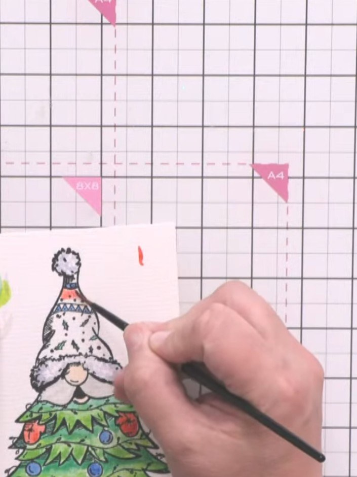 Step 3: Using watercolours, add red to the gnome's hat and white to the beard area. Apply the colours with a brush, bu