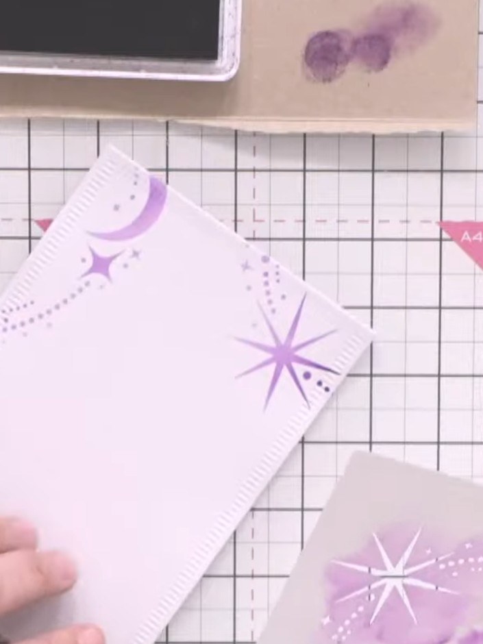 Step 3: Position the 7 by 7 inch stencil around the edges of the card, ensuring the decorative star and moon patterns 