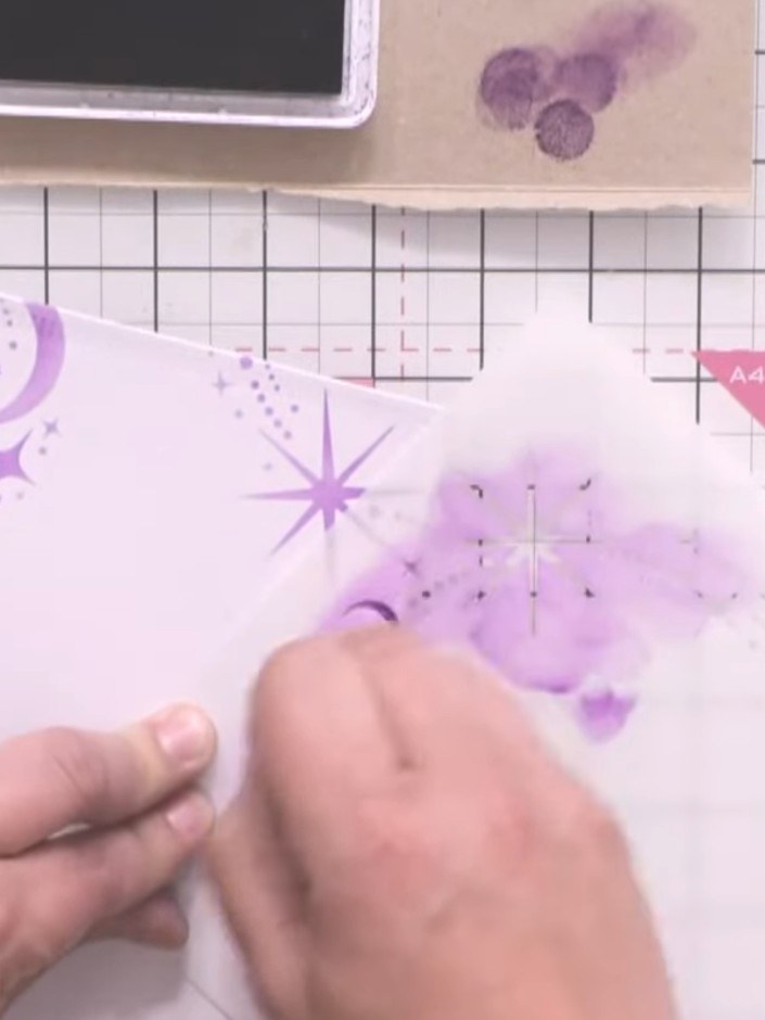 Step 4: Position the stencil on your card base and apply purple ink through the design to create a decorative celestia