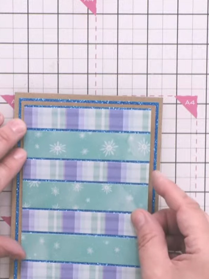 Step 5: Cut the striped patterned paper from the Mystical Christmas pad into alternating strips of blue with snowflake