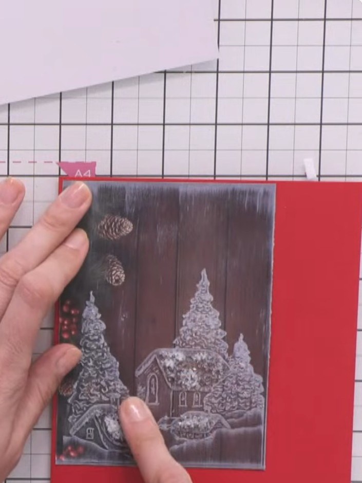 Step 3: Apply clear drying glue to the roofs of the embossed houses on the winter village scene. Use your fingers to s
