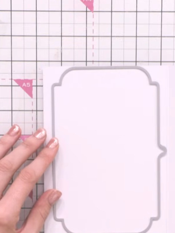 Step 1: Cut two pieces from white cardstock using the traditional borders die. Position the die on the cardstock and r