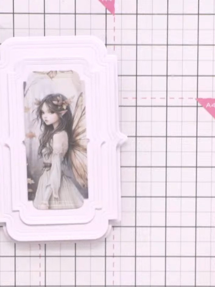 Step 8: Apply adhesive to the back of the white layered fairy frame and attach it to the front of your card base, posi
