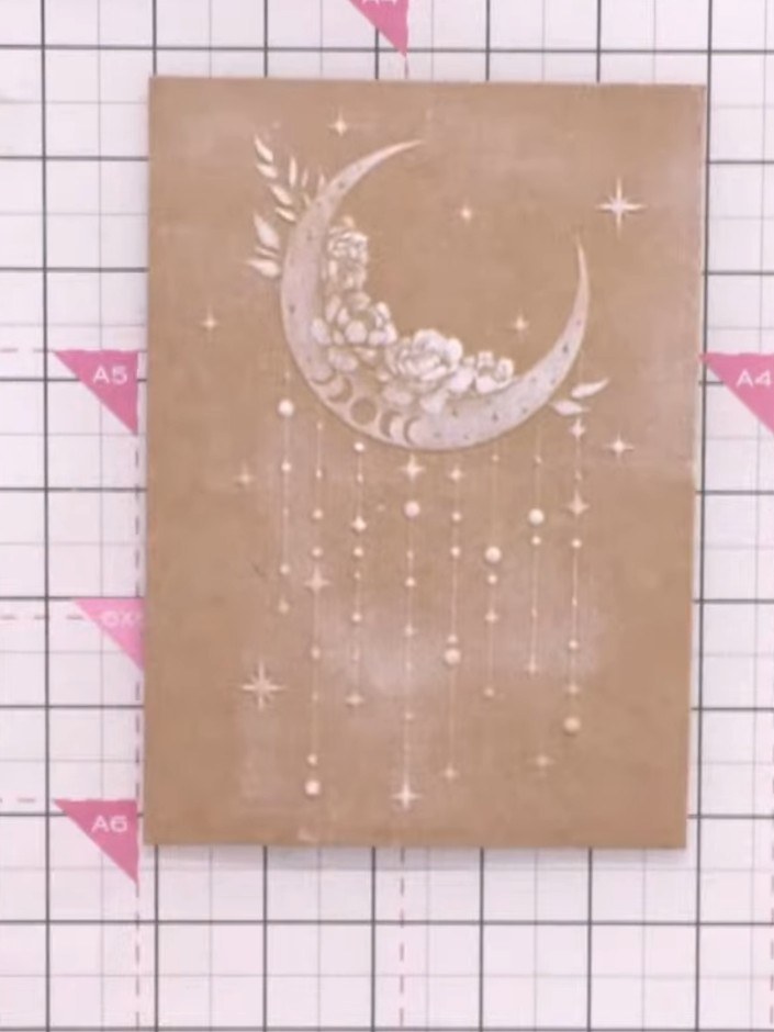Step 3: Use a brush or your finger to blend away any excess white ink from the embossed design, creating a clean and s