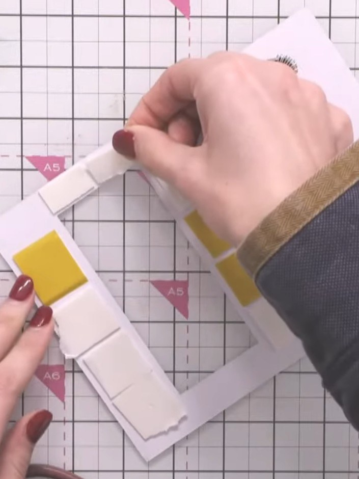 Step 6: Place thin foam pads at the opposite end of the window panel from the yellow squares to act as stoppers. This 
