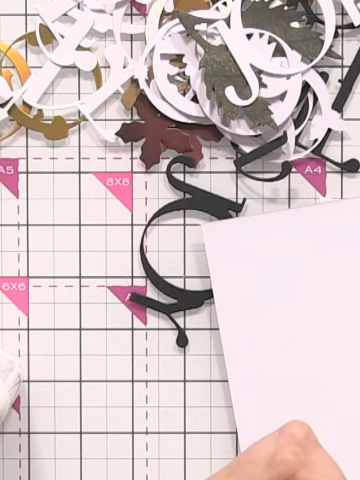 Step 2: Stanze das Joy-Wort mit der Stanzschablone aus weißem Cardstock aus.