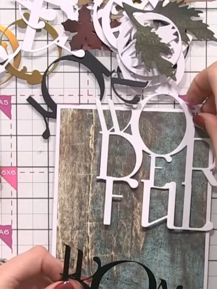 Step 3: Cut out the 'WONDERFUL' sentiment from black cardstock and position it behind the white 'JOY' die-cut to creat