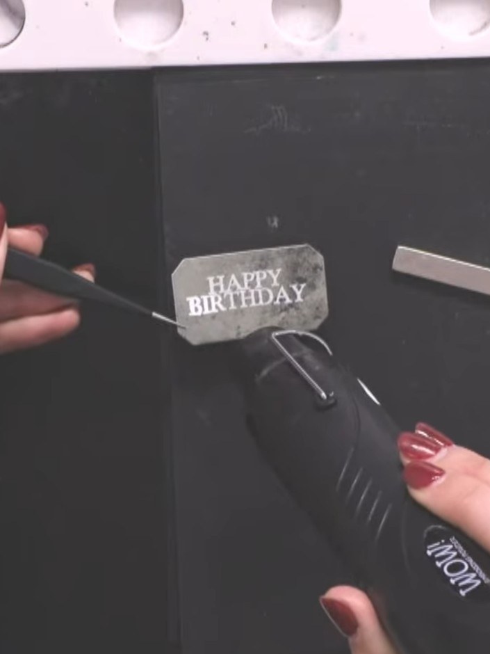 Step 10: Heat emboss the stamped 'Happy Birthday' sentiment using a heat gun. Hold the heat gun over the embossing powd
