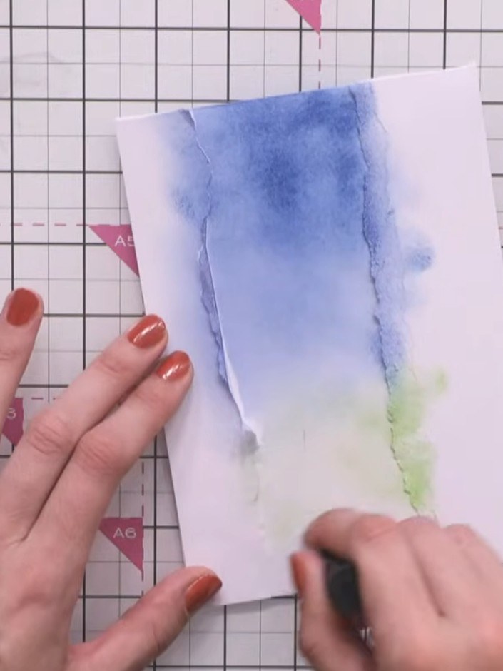 Step 4: Begin blending green ink into the lower portion of the card, working it upwards to create a smooth transition 