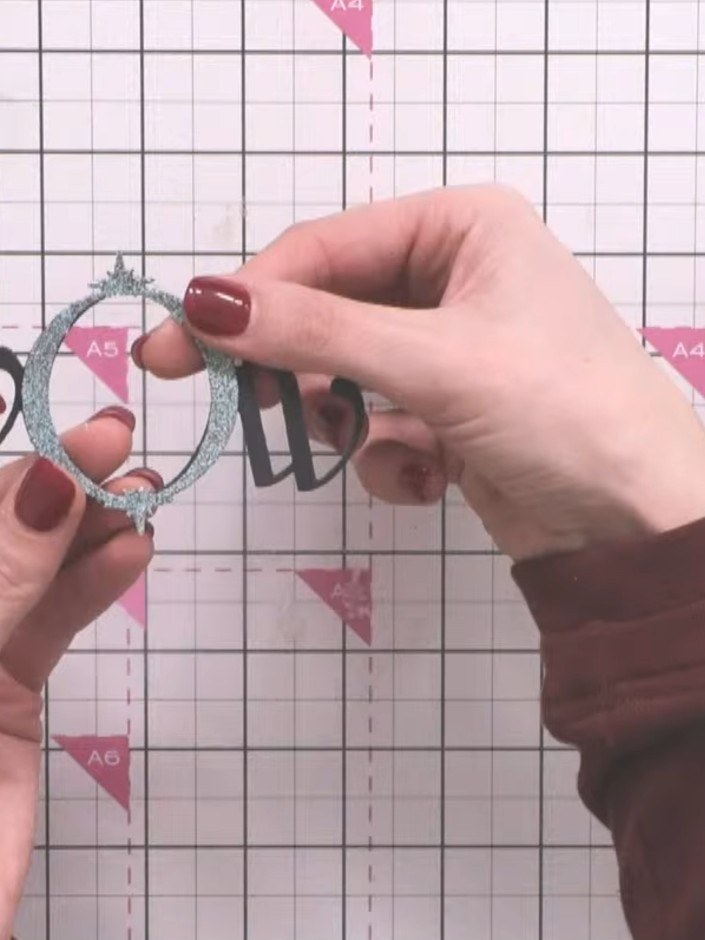 Step 2: Layer the oval die-cut frames on top of each other, starting with the largest silver glitter oval and working 