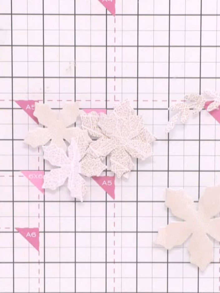 Step 4: Cut out poinsettia flowers from the Holly and Berry die set. Apply colourless glitter to each petal using fast