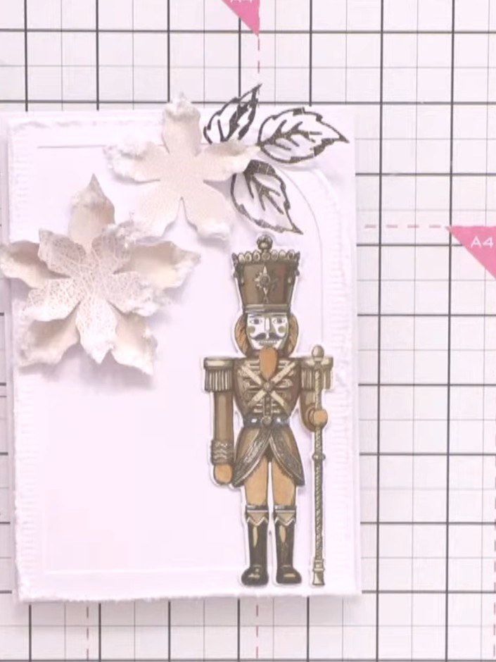 Step 7: Add green foliage die-cut pieces from the Holly and Berry collection around and beneath the white poinsettias 