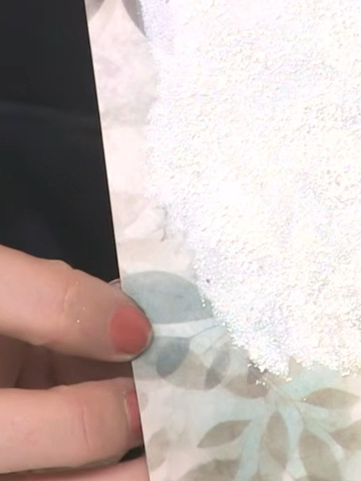 Step 7: Schneide die embosste weiße Karte mit einem Papierschneider auf die passende Größe zu.