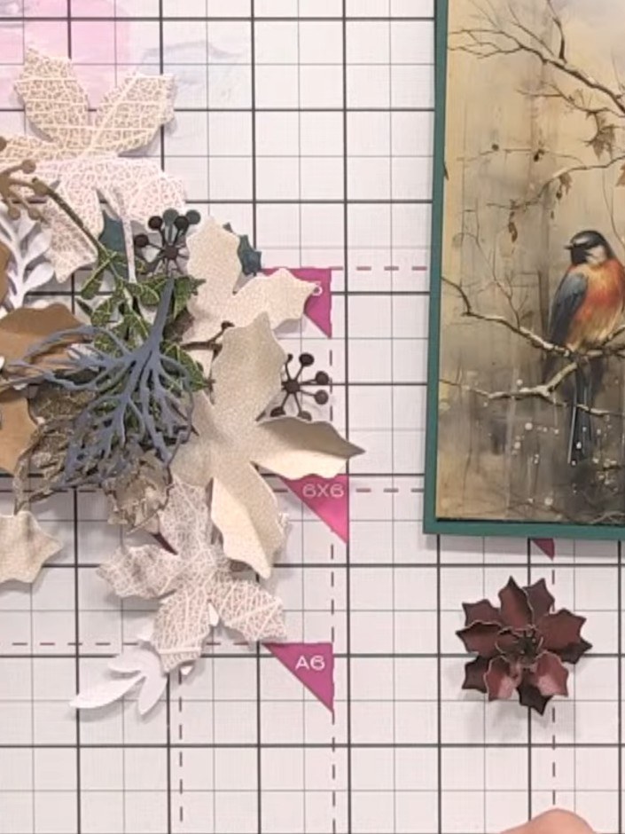 Step 5: Die-cut skeleton leaf foliage pieces from the Holly & Berry papers. Arrange and layer them as greenery around 