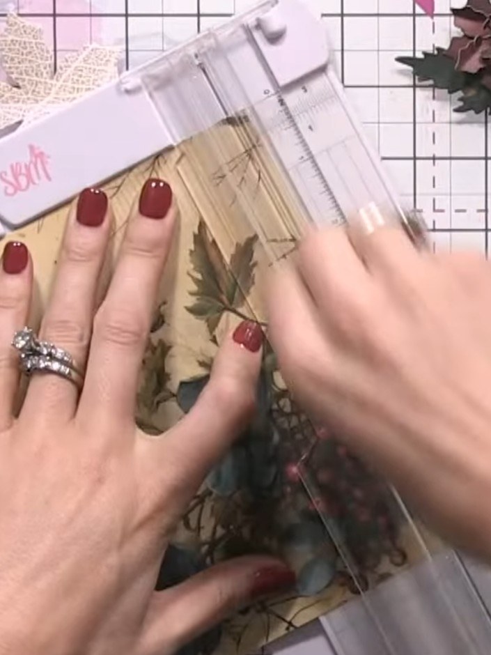 Step 7: Arrange the poinsettia flowers, greenery and pine cone on your card base. Tuck leaves under elements to create