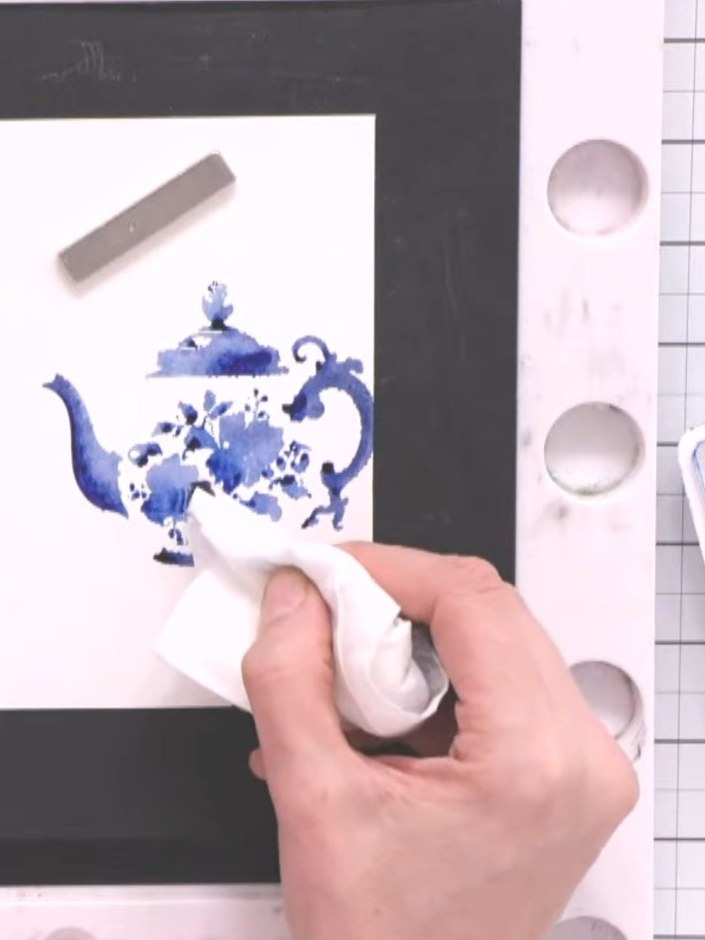 Step 5: Use a dry baby wipe to blot away excess water and puddles from the teapot image, whilst keeping the blue water