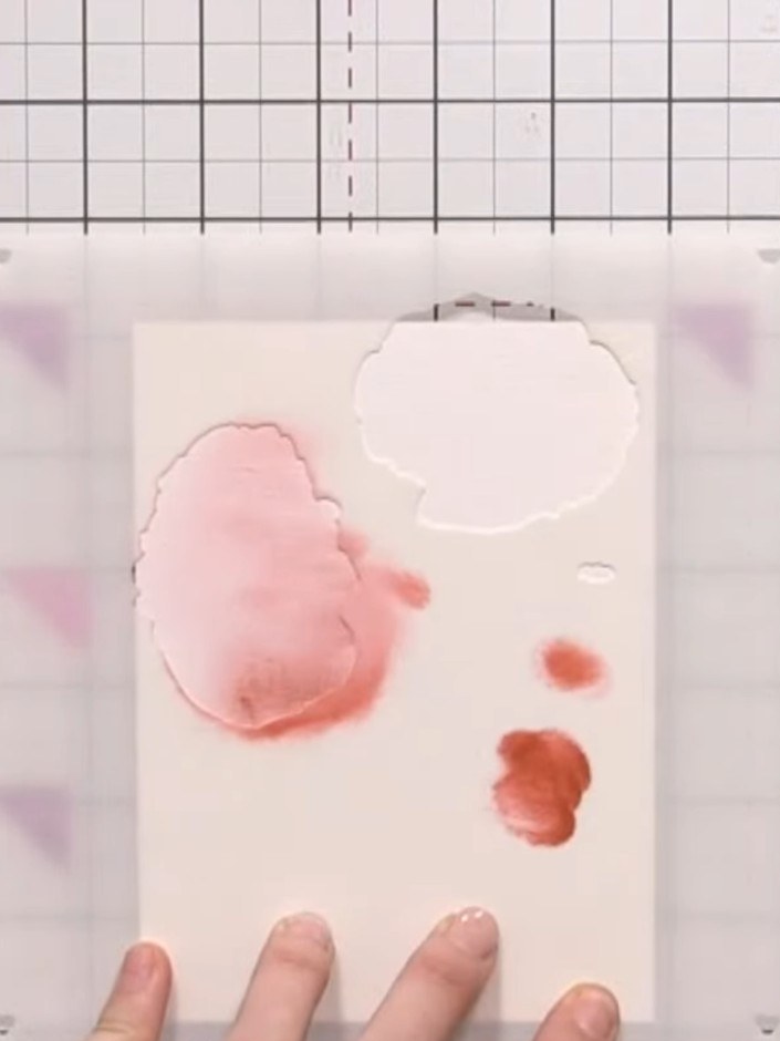 Step 5: Remove the first stencil carefully. Position the second petal layer stencil on top of your card, aligning it c