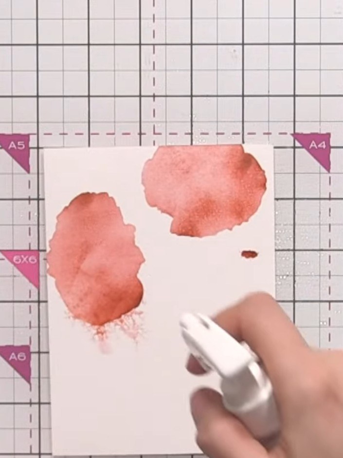 Step 7: Spray the inked layer lightly with water using a spray bottle. Allow the coral ink to bleed and blend naturall