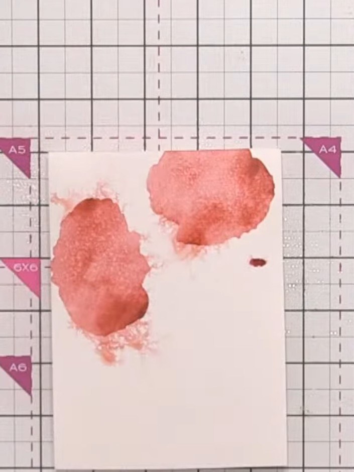 Step 8: Position stencil number three over your card and apply red ink with a firmer press to create darker tones. Opt