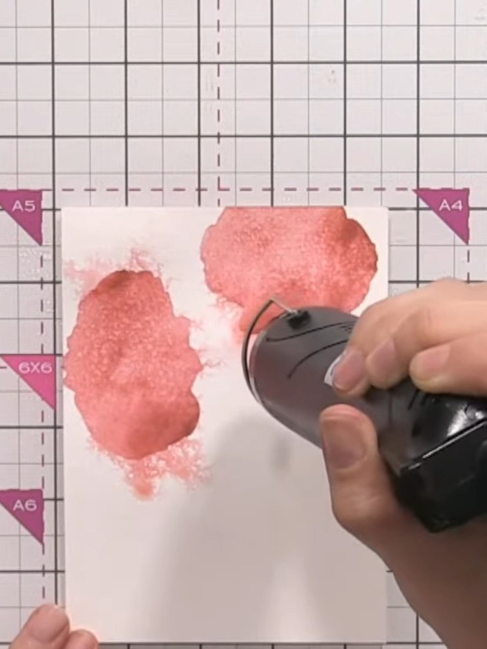 Step 9: Position stencil number four over the watercolour background. Press firmly and tap the ink pad onto the stenci