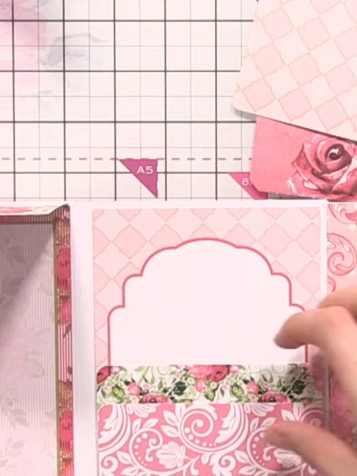 Step 8: Layer and stack the patterned paper pockets vertically on the album page to create three-tier storage sections