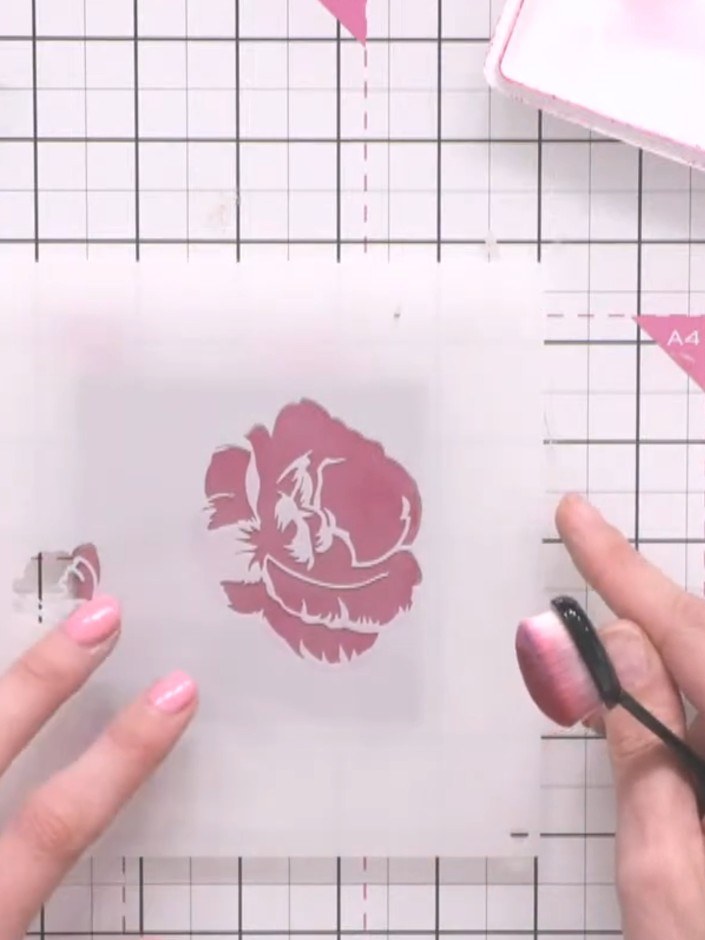 Step 4: Remove the first stencil and position the second stencil layer over the coaster. Tap lightly with the pink ink