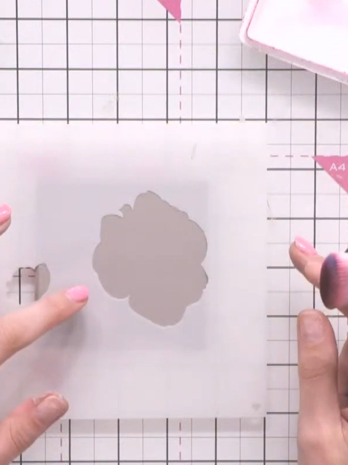 Step 6: Hold the stencil firmly in place over the coaster. Using a pink ink pad, tap lightly over the stencil opening 