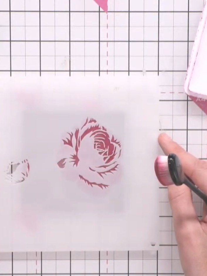 Step 9: Continue building up layers by applying additional stencil layers using pink, teal, and green inks. Use the fi