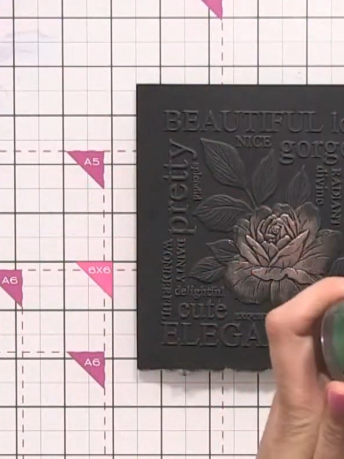 Step 5: Select a green gilding wax and apply it to the embossed leaves on the design using your finger. Gently rub the
