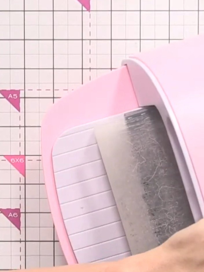 Step 2: Place the embossing folder with the grey card inside into the pink die-cutting machine. Run the card through t