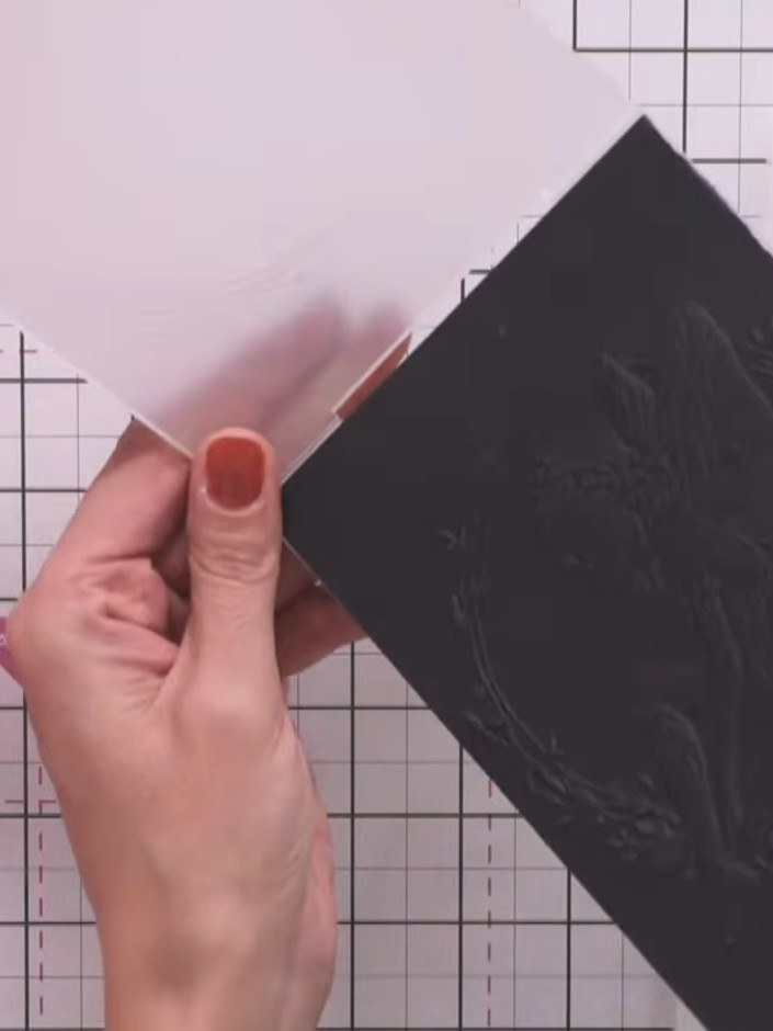 Step 2: Place the black card with the embossing folder into your embossing machine. Run it through the machine to crea