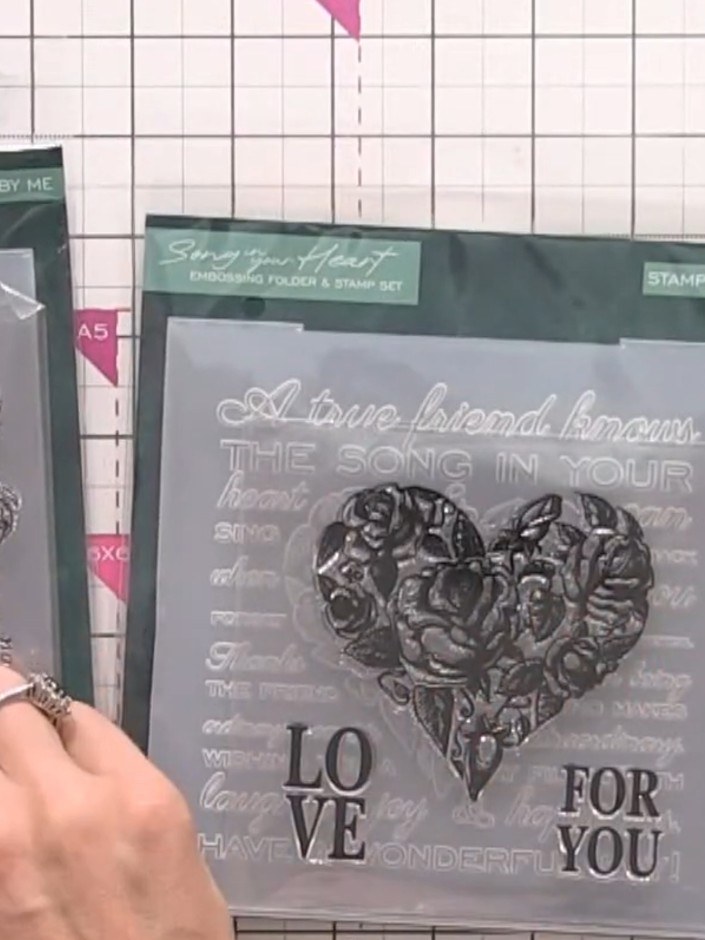 Step 1: Place your black card stock into the embossing folder with the heart design. Position the folder and card into