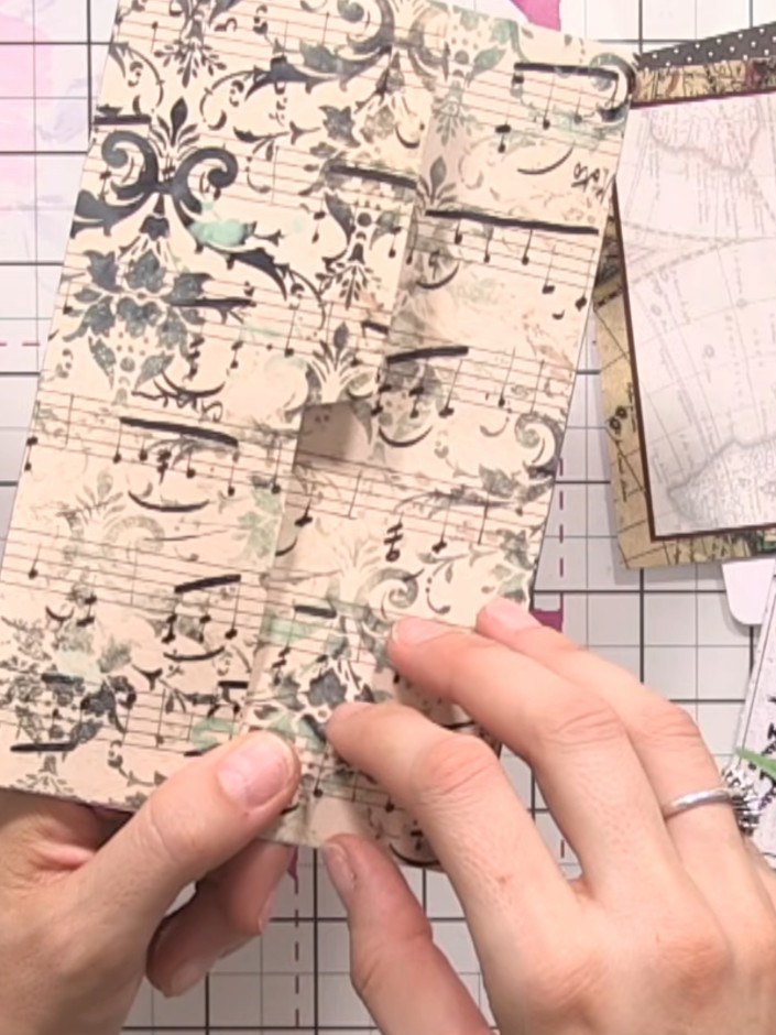 Step 4: Fold the decorative paper piece along the scored lines to create the internal page structure. Use your fingers