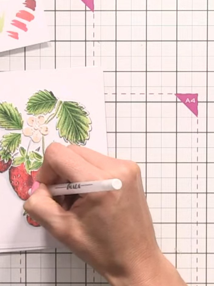 Step 10: Use a white gel pen to add highlights and bring back detail on the strawberries and leaves, focusing on the li