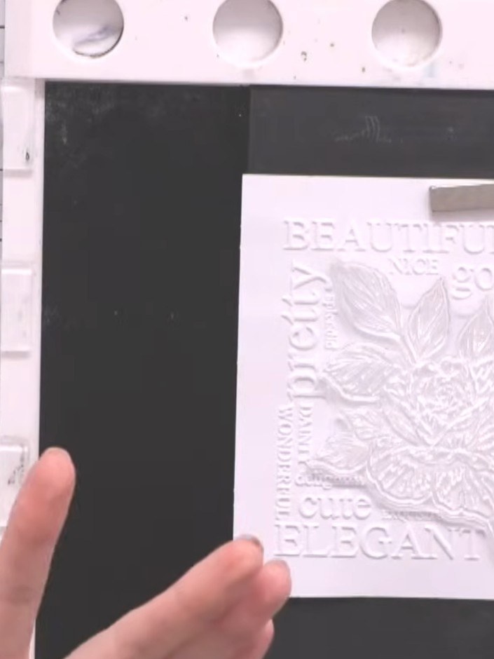 Step 3: Place the embossed white card panel onto a piece of black card stock. Run both pieces together through your di